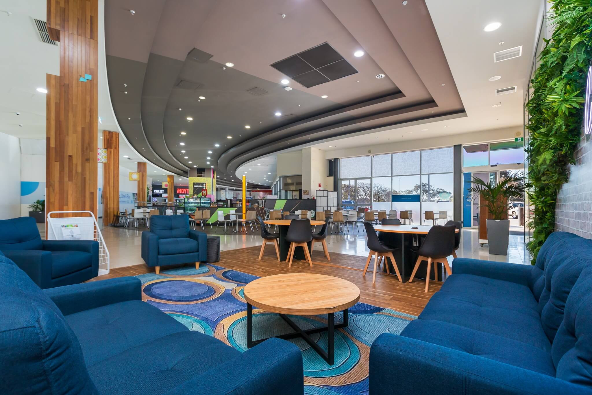 Co-working dwell zone at Southlands Boulevarde Shopping Centre featuring blue couches, geometric rug and tables